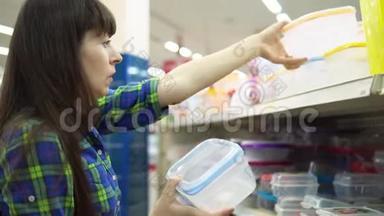 一个年轻的女人选择并在超市买一个塑料容器作为食物。